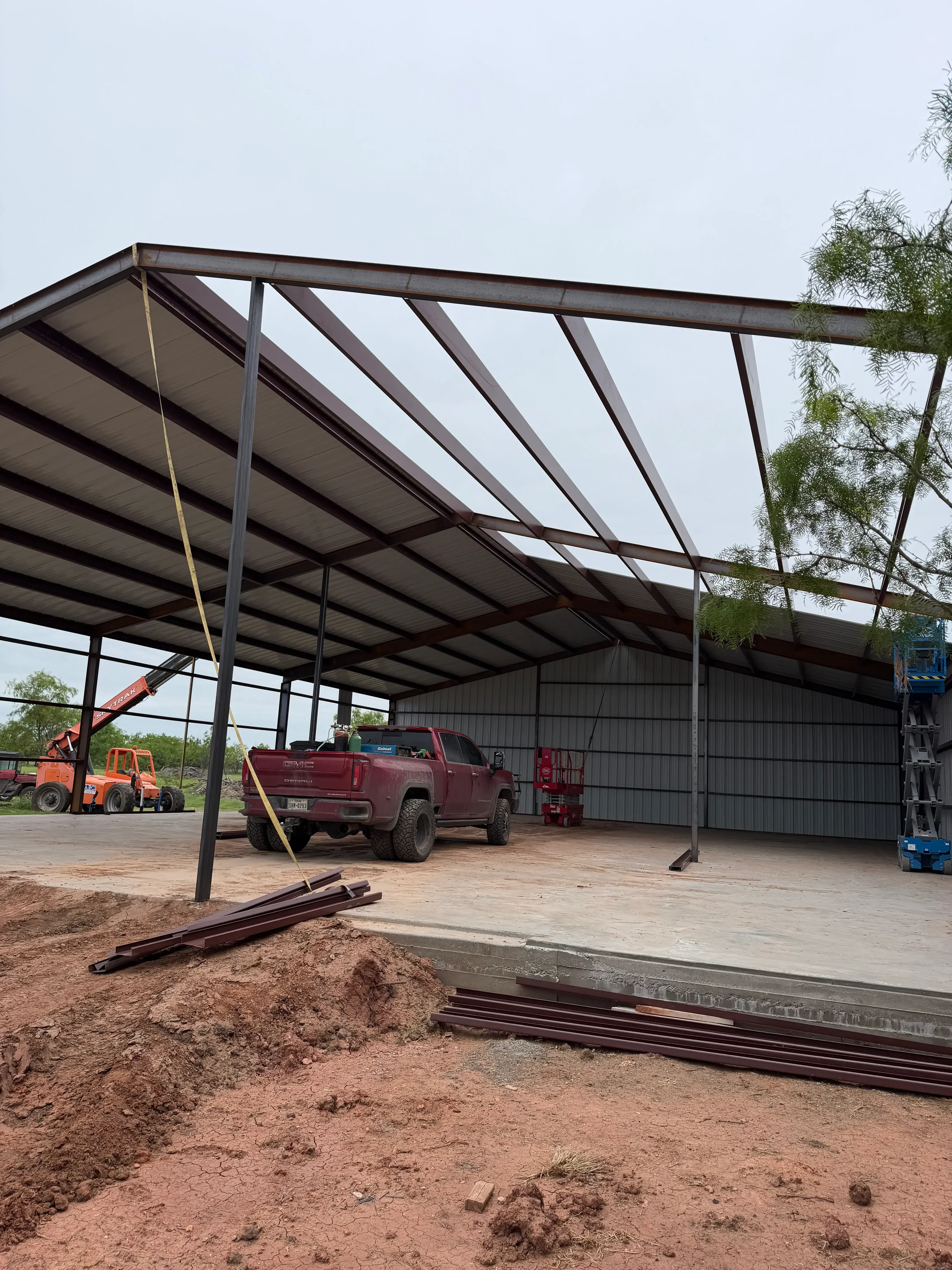 Welded steel frame structure with horizontal bracing and support posts on concrete foundation