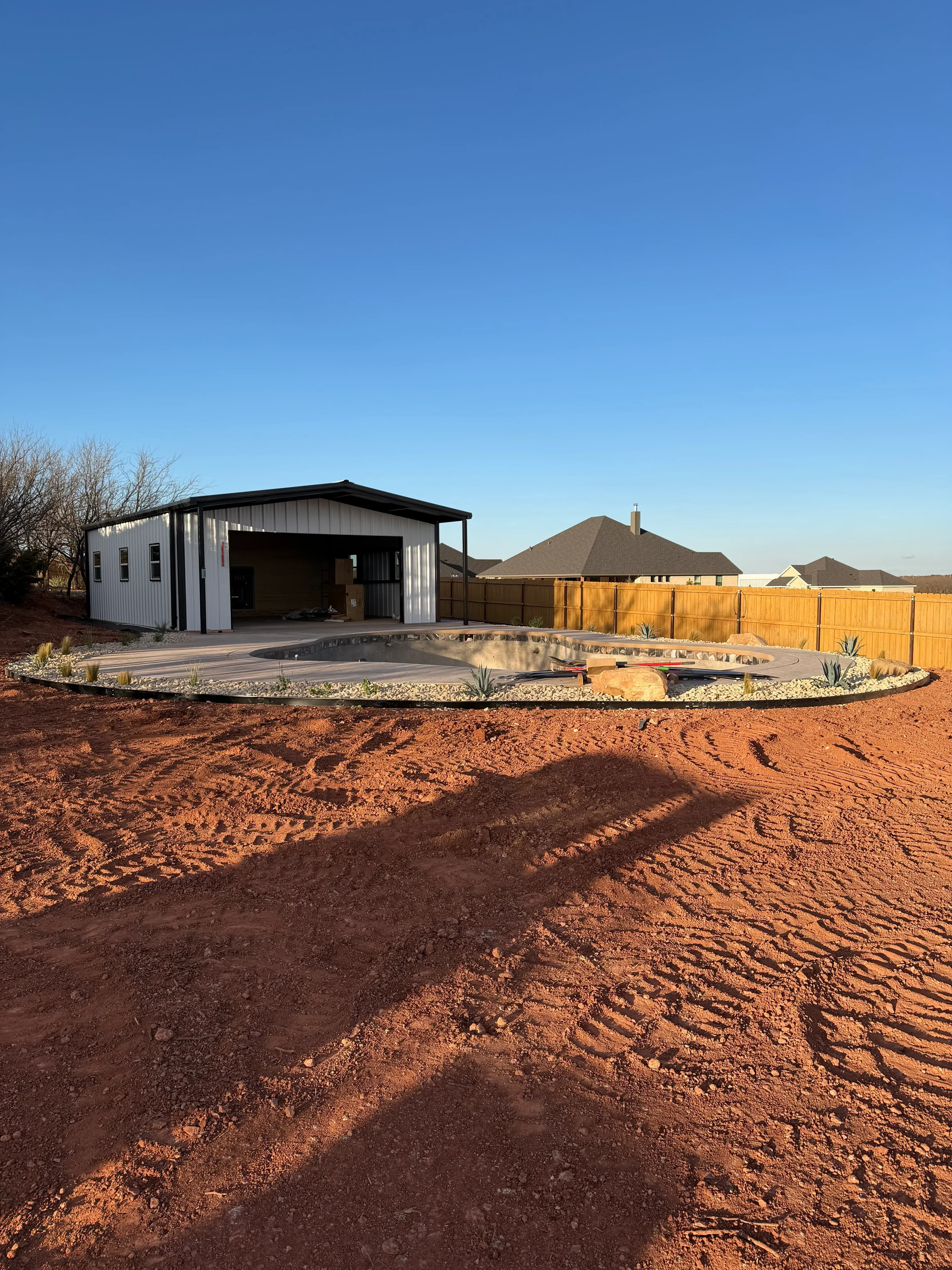 Compacted red clay driveway with grading and landscape preparation work